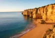 Kustlijn van de Algarve met kliffen en een leeg strand in de late middagzon
