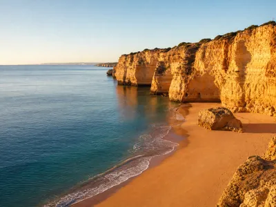 Kustlijn van de Algarve met kliffen en een leeg strand in de late middagzon