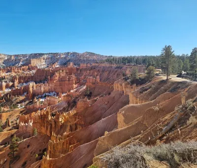 Uitzicht op de roodoranje hoodoos van Bryce Canyon met stukken sneeuw op de hellingen
