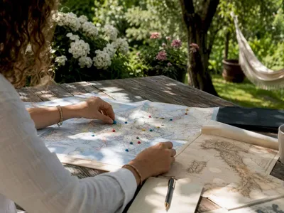 Handen die routekaartjes op een Europese spoorwegenkaart leggen