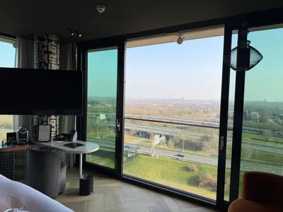 Hoge hotelkamer van Van der Valk Eindhoven-Best met bed, tafel en panoramisch raam