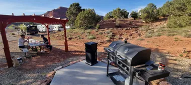 Drie vrienden ontbijten buiten naast hun camper op een kampeerplek in Utah