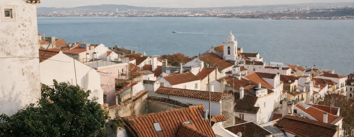 Uitzicht over de daken van Alfama in Lissabon met de Taag op de achtergrond
