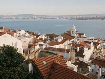 Uitzicht over de daken van Alfama in Lissabon met de Taag op de achtergrond