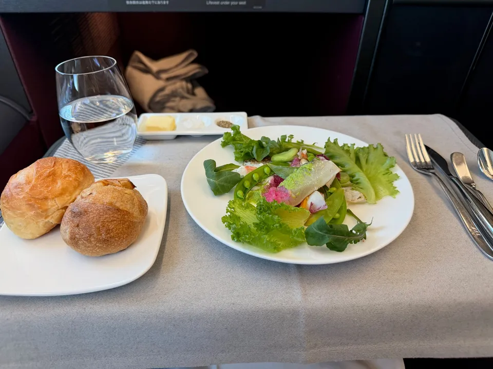 Salade met broodjes en een glas water op de terugvlucht vanaf Tokyo