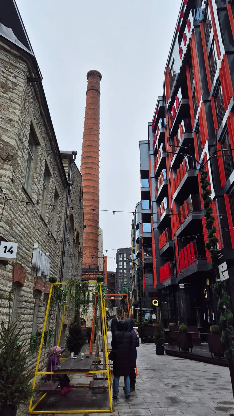 De hoge bakstenen schoorsteen van de Rotermann-wijk tussen nieuwbouw in Tallinn