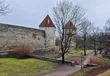 De middeleeuwse stadsmuur van Tallinn met twee torens met rode spitsen, op een grijze winterdag
