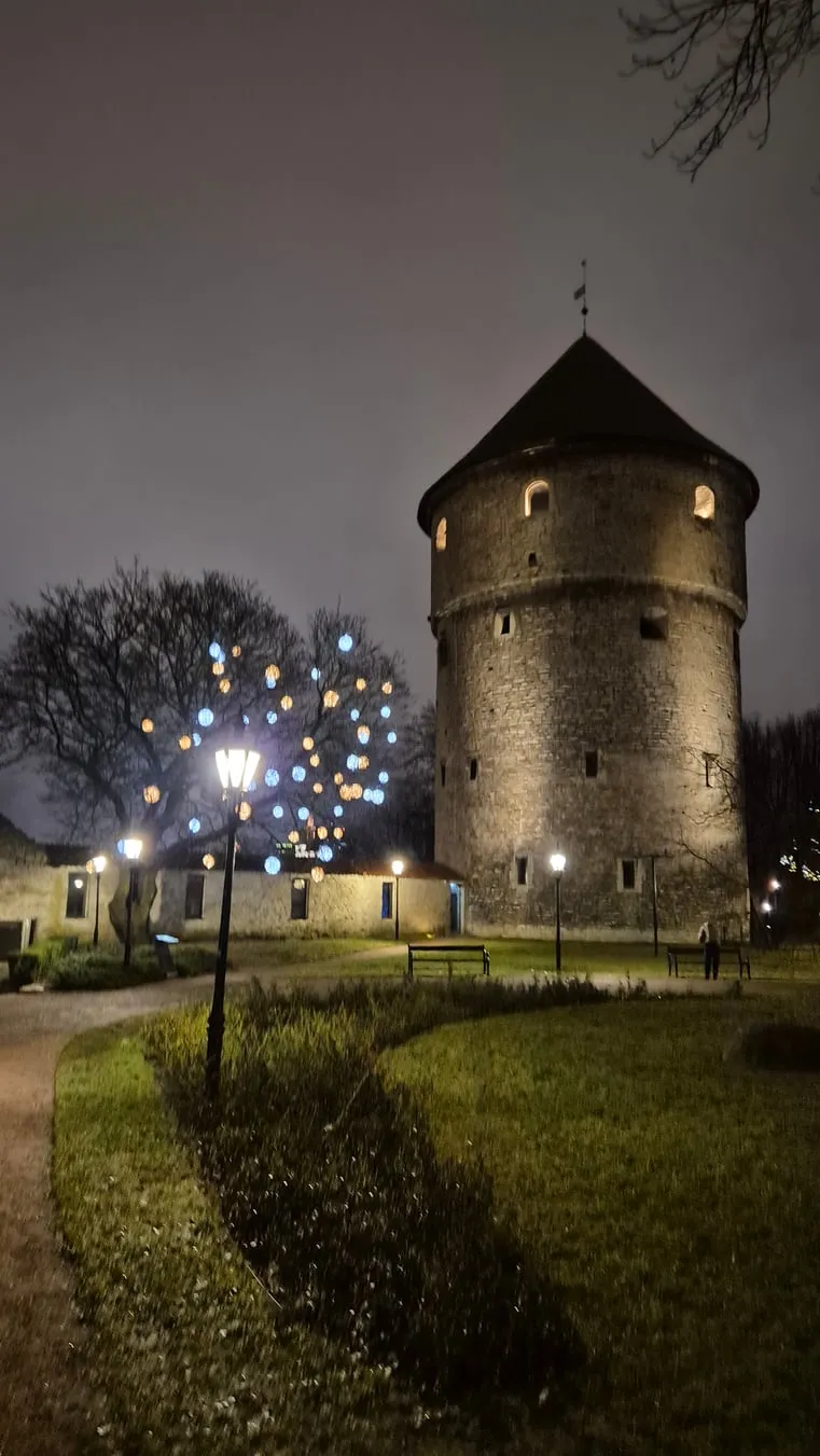 Een ronde middeleeuwse toren van de stadsmuur van Tallinn, verlicht in de avond