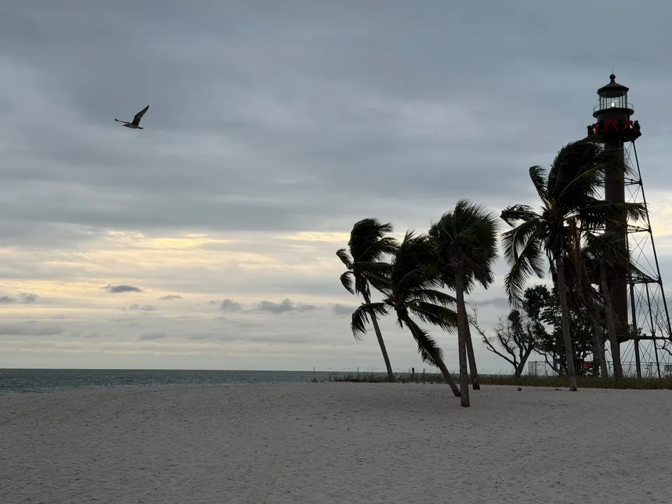 Sanibel Lighthouse met kerstkrans en palmen die buigen in de wind